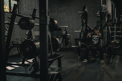 A man sitting in a gym with a barbell