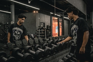 A couple of men standing next to each other in a gym