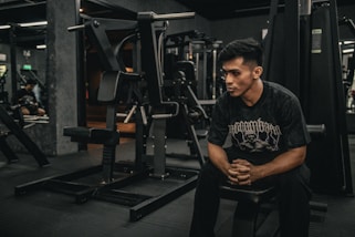 A man sitting on a bench in a gym