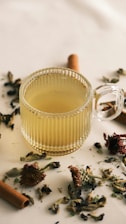 A glass cup filled with tea next to a cigarette
