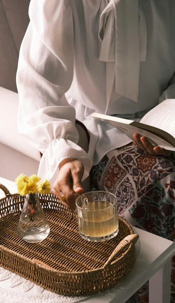 A person sitting at a table with a basket of flowers