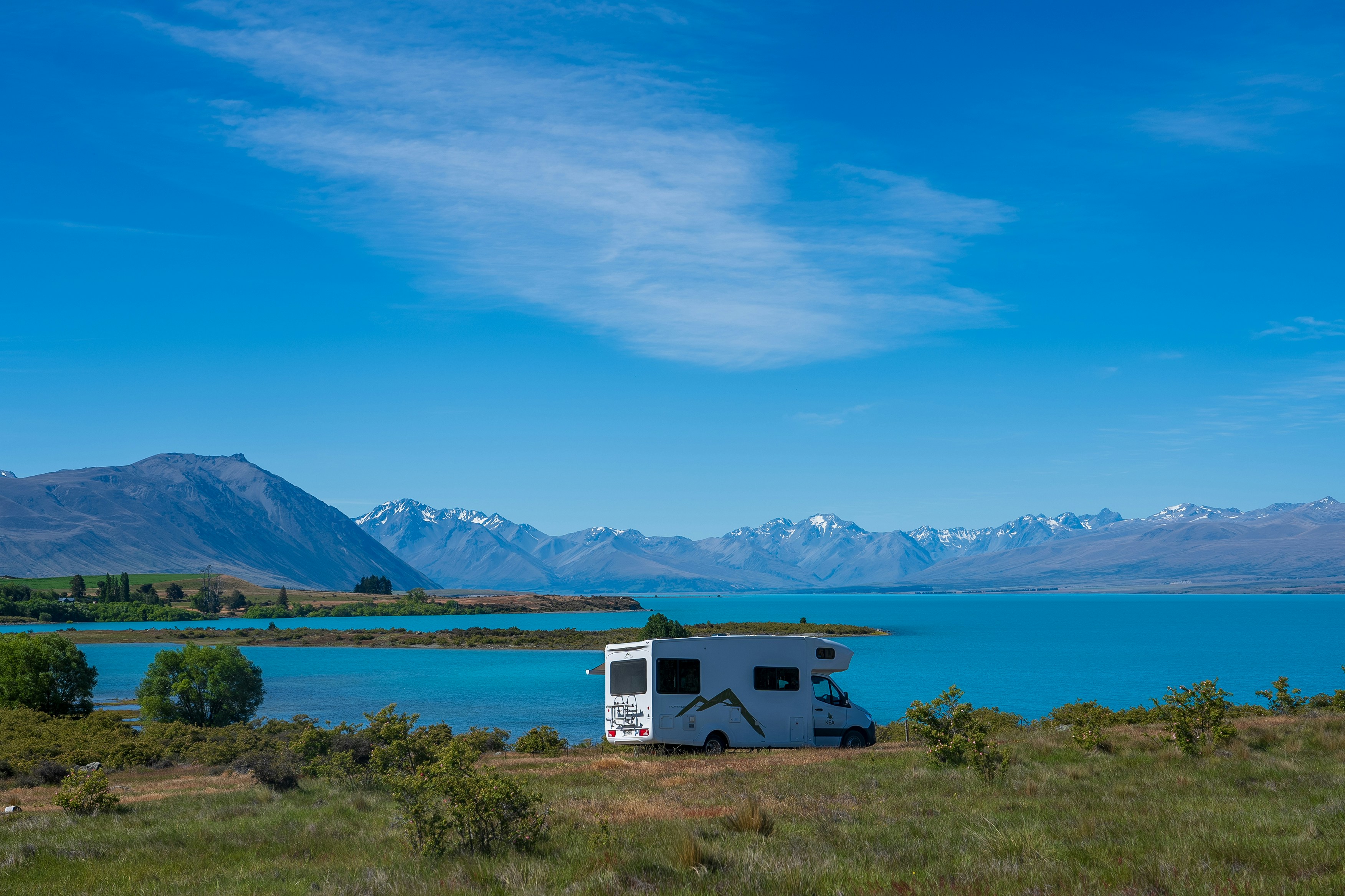 An rv parked on the side of a lake