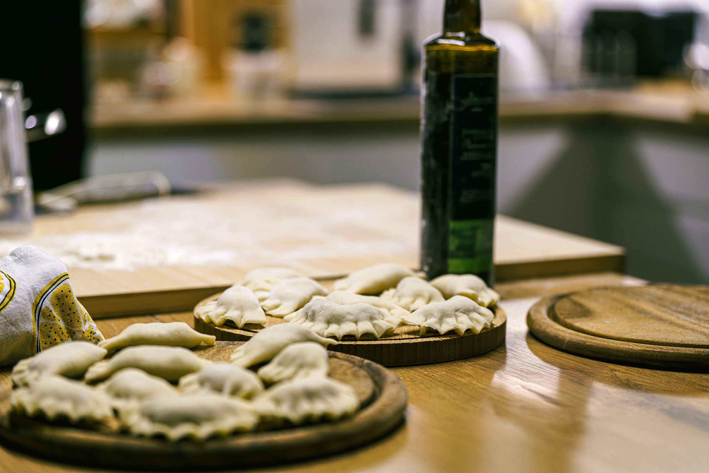 A wooden table topped with pizzas and a bottle of wine