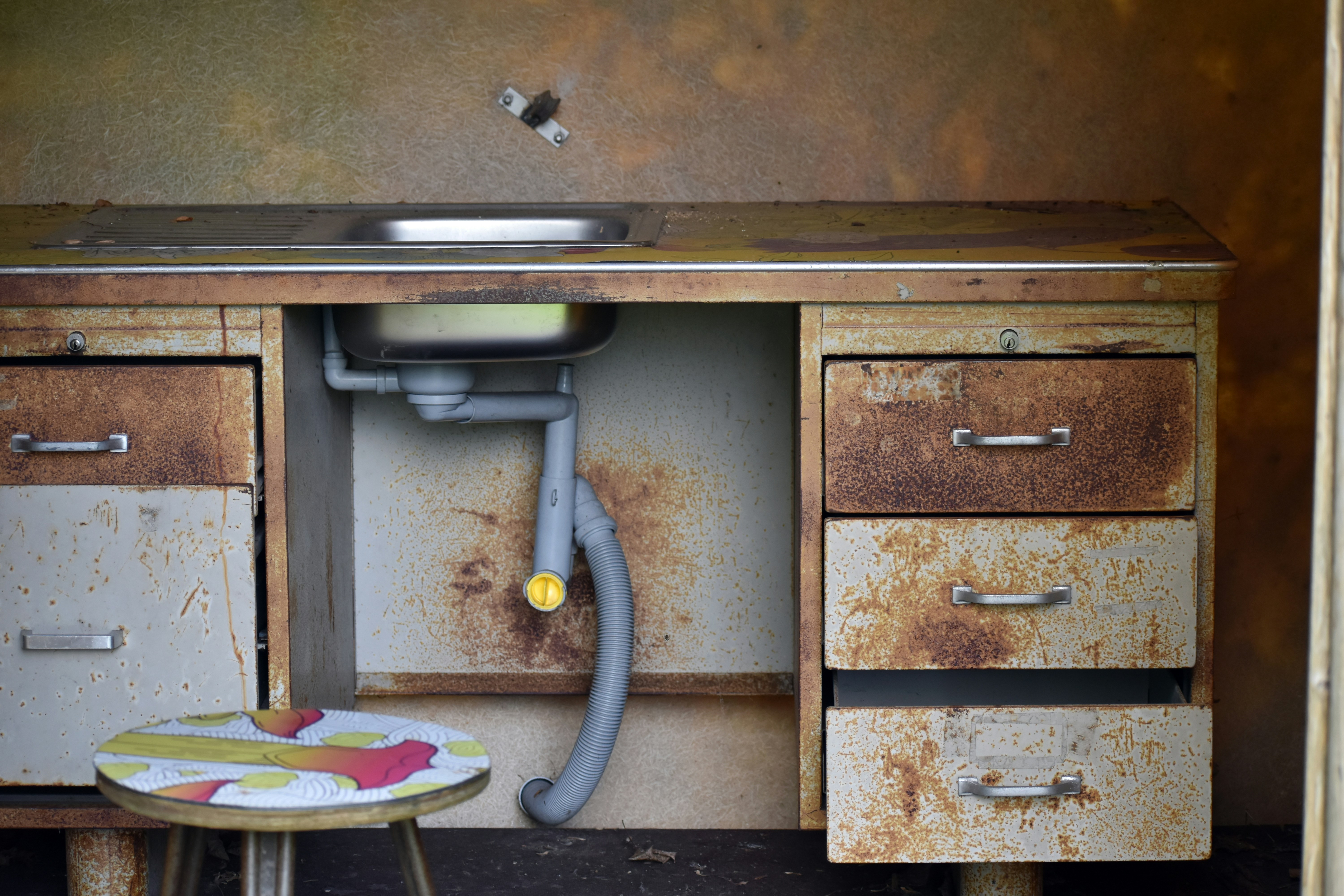Technician repairing damaged drain pipe to restore proper water flow.