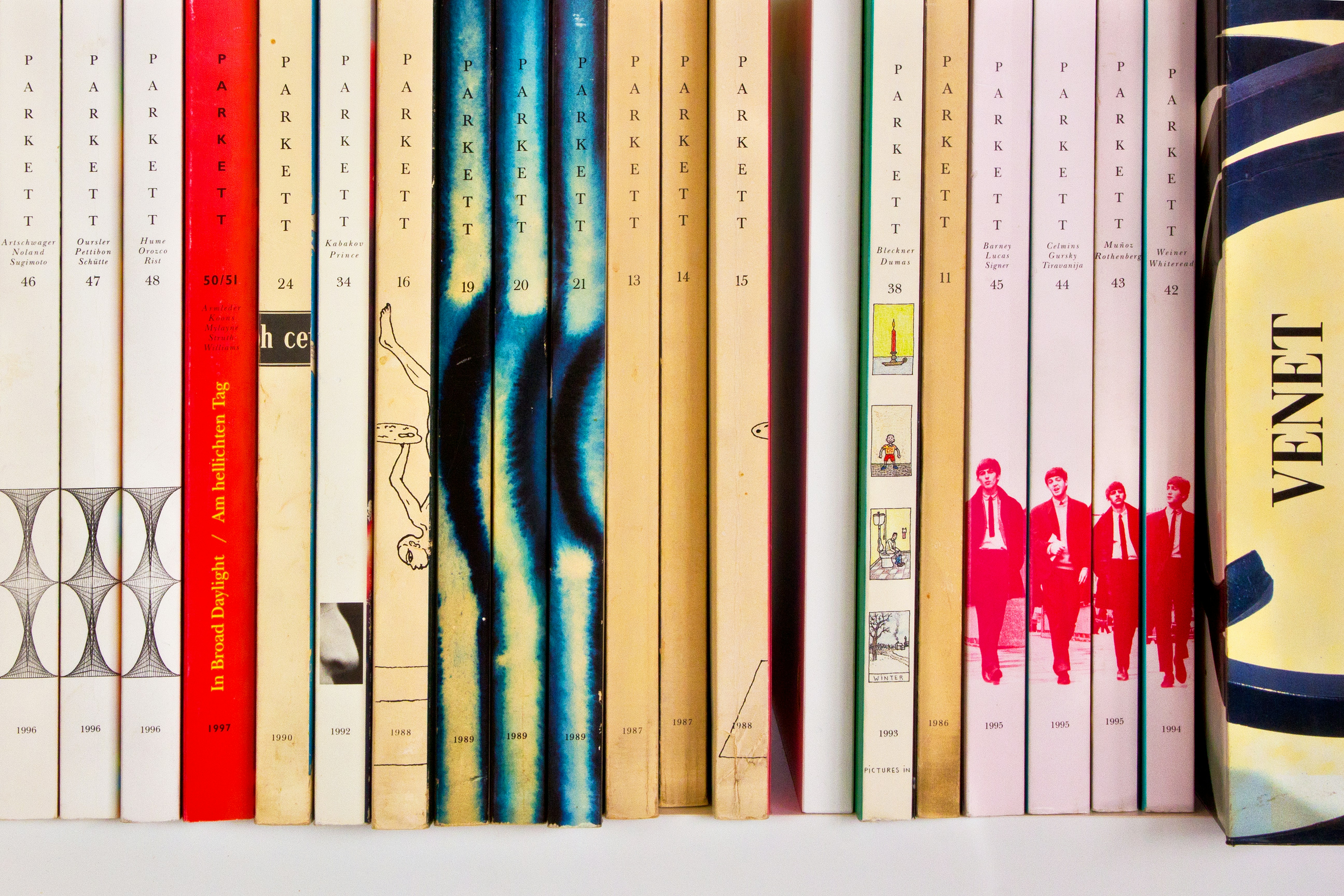 A row of books sitting on top of a white shelf