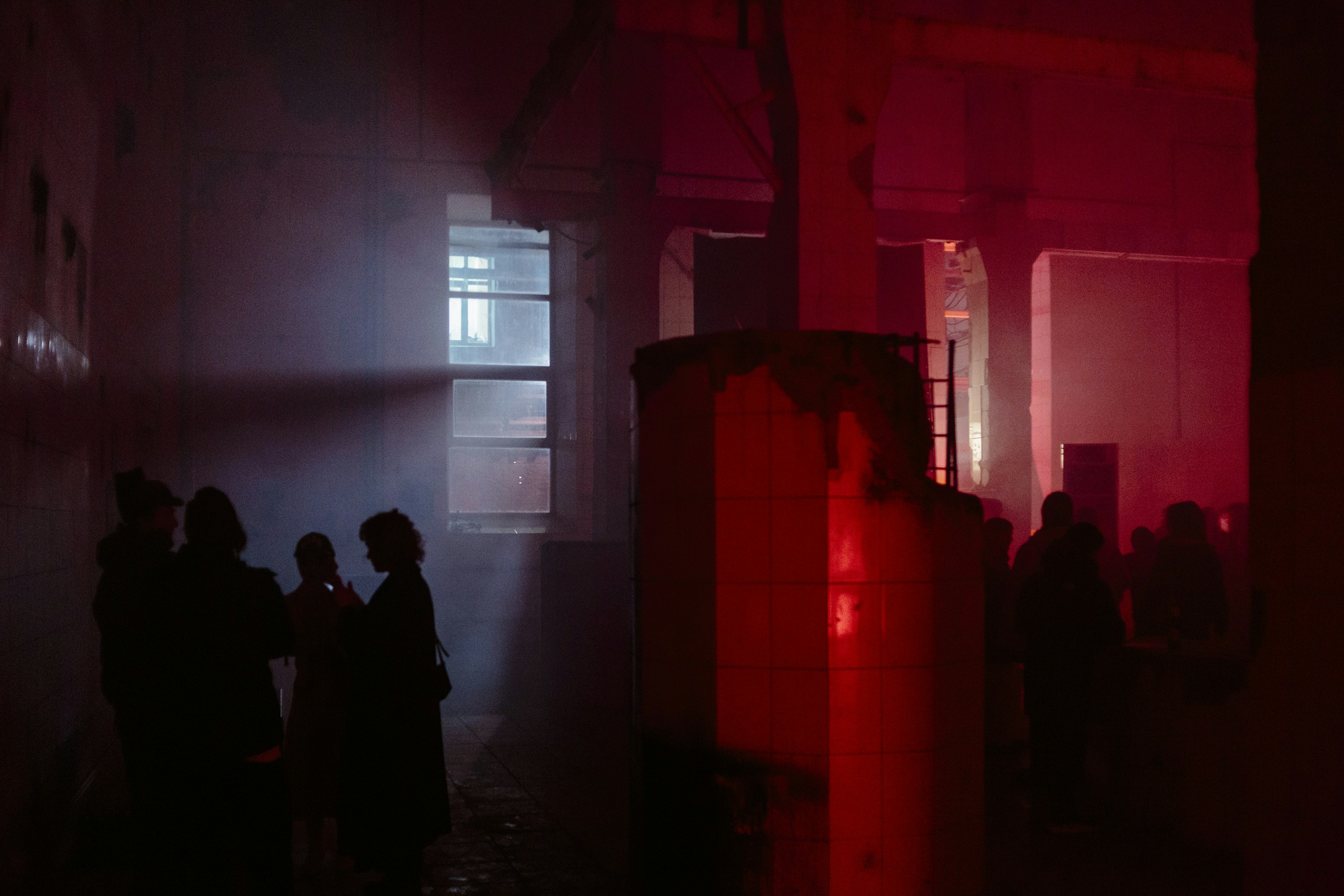 A group of people standing around in a dark room