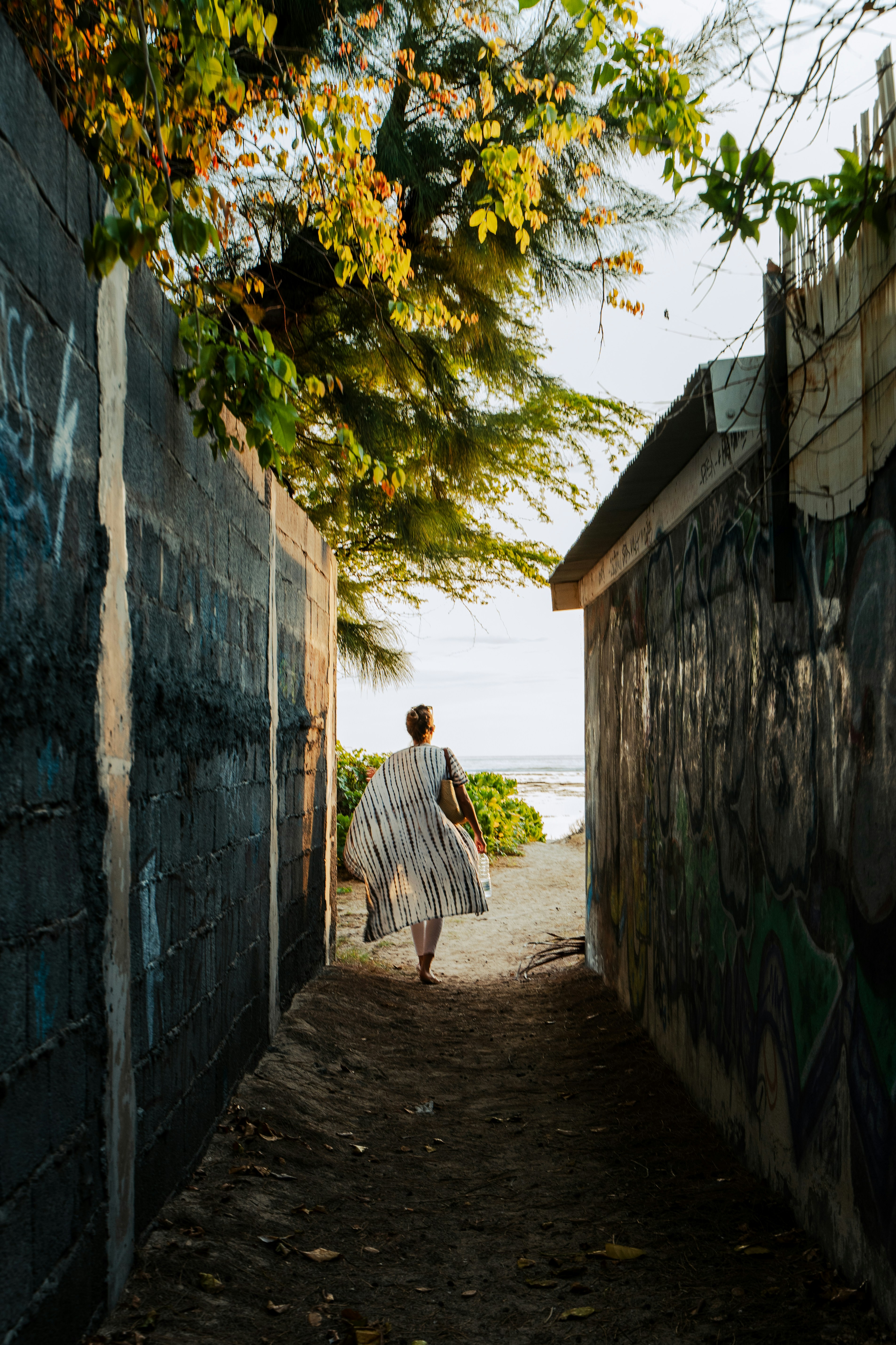 A woman walking down a narrow alley way