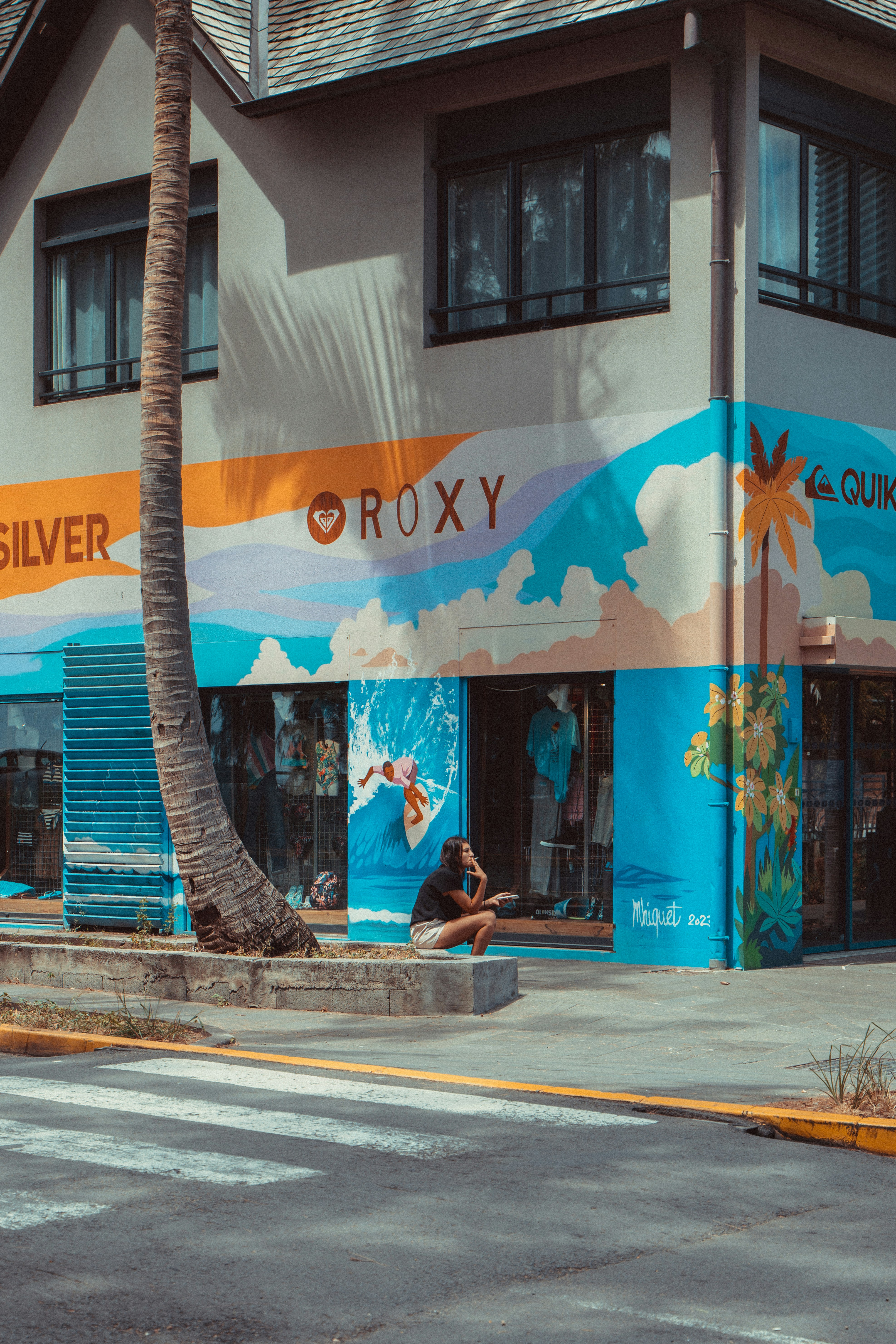 A person sitting on a bench in front of a building