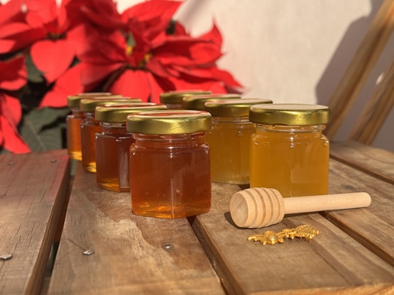 A wooden table topped with jars of honey