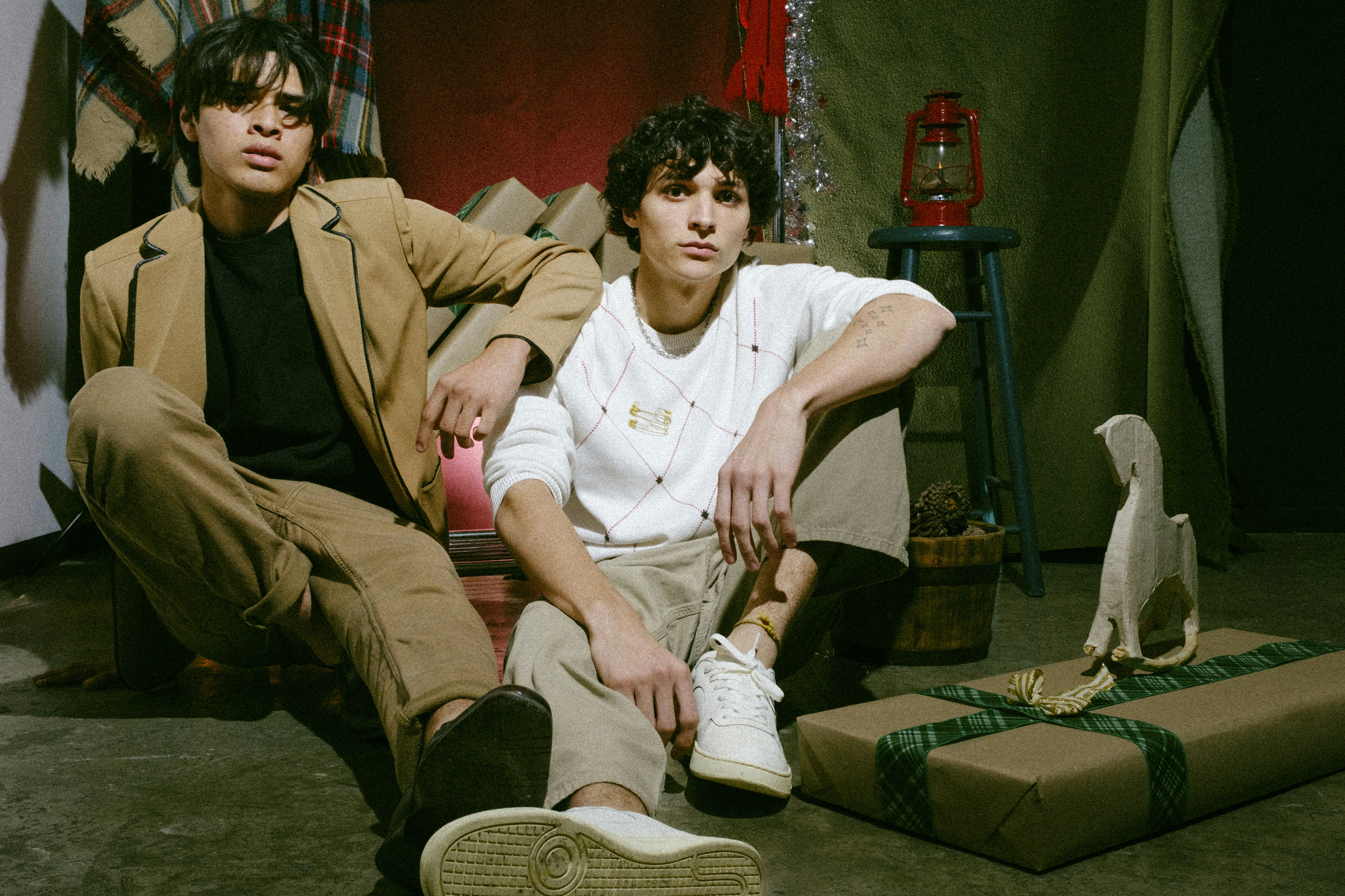 Two young men sitting on a couch next to a bird