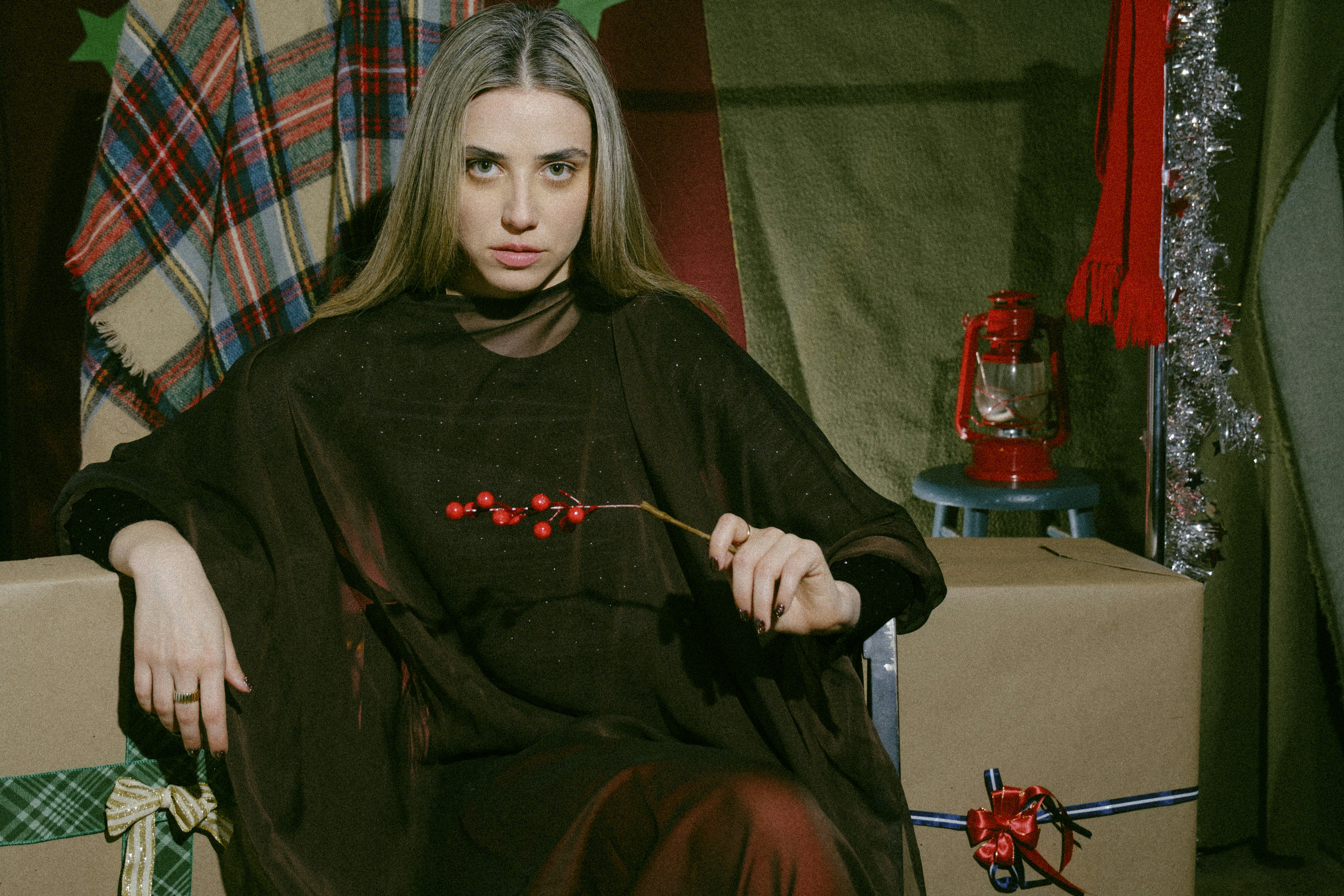 A woman sitting in a chair next to a christmas tree