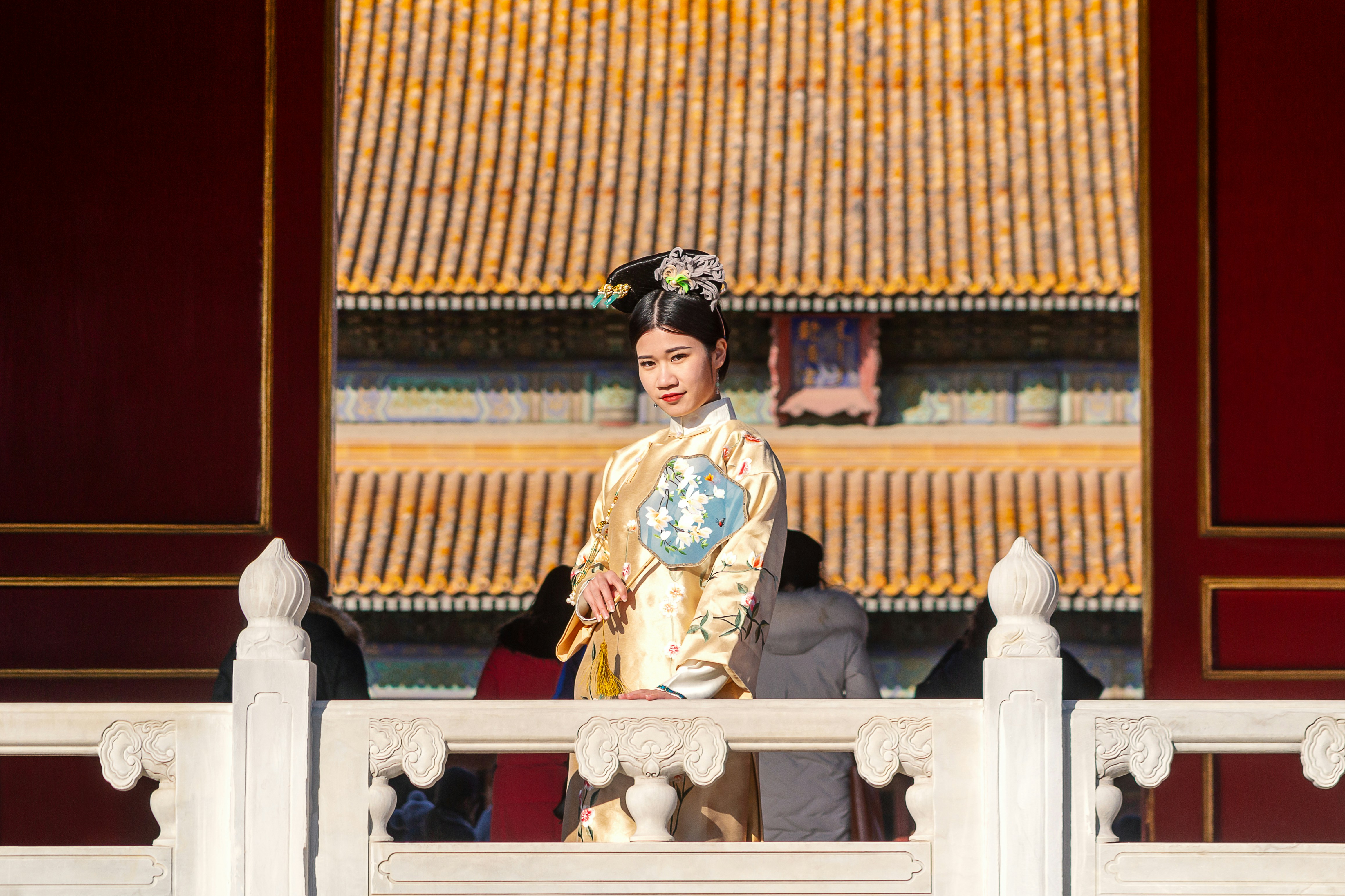 A woman in a traditional chinese dress standing on a balcony