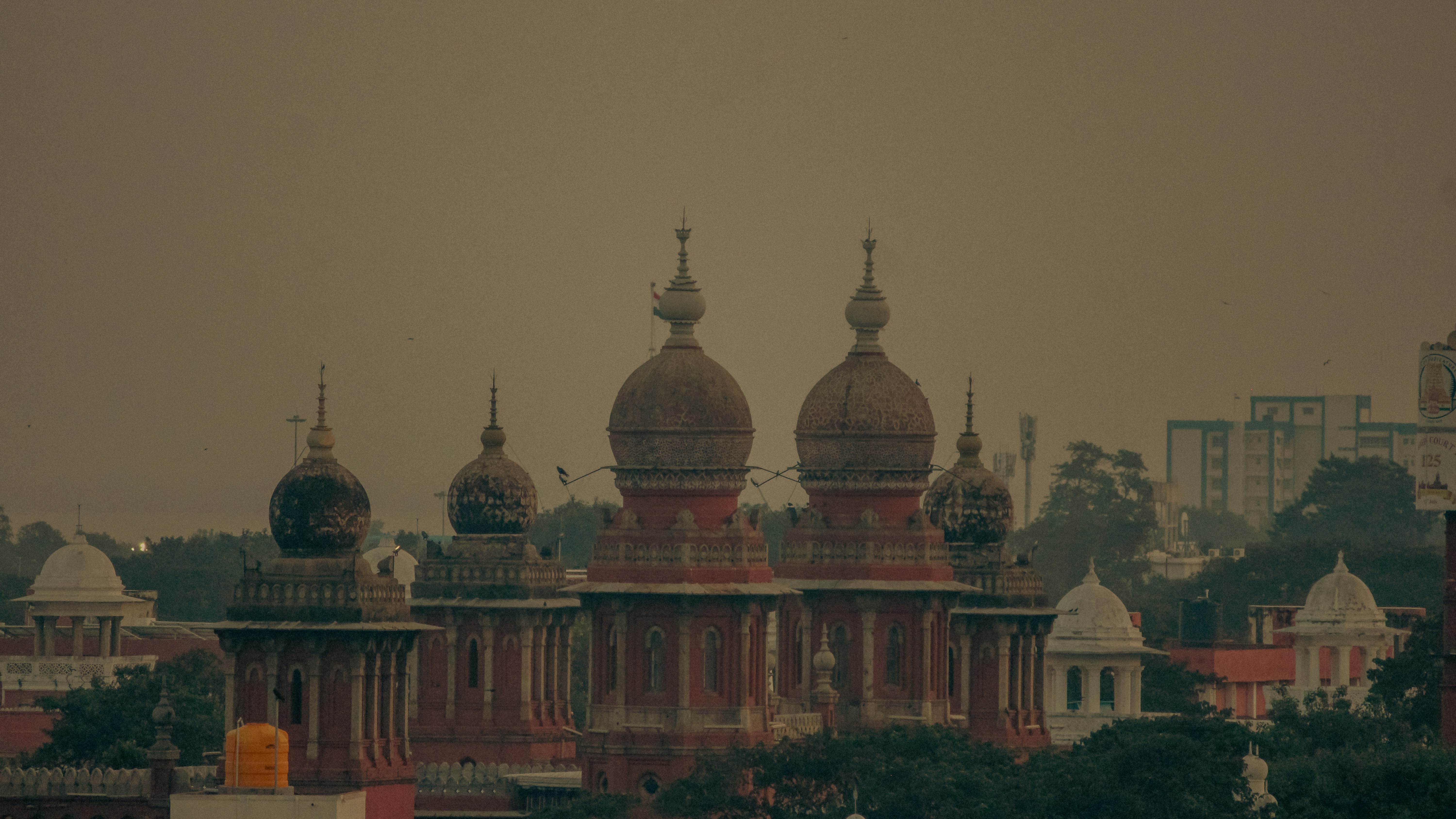 A view of a city with a plane flying in the sky