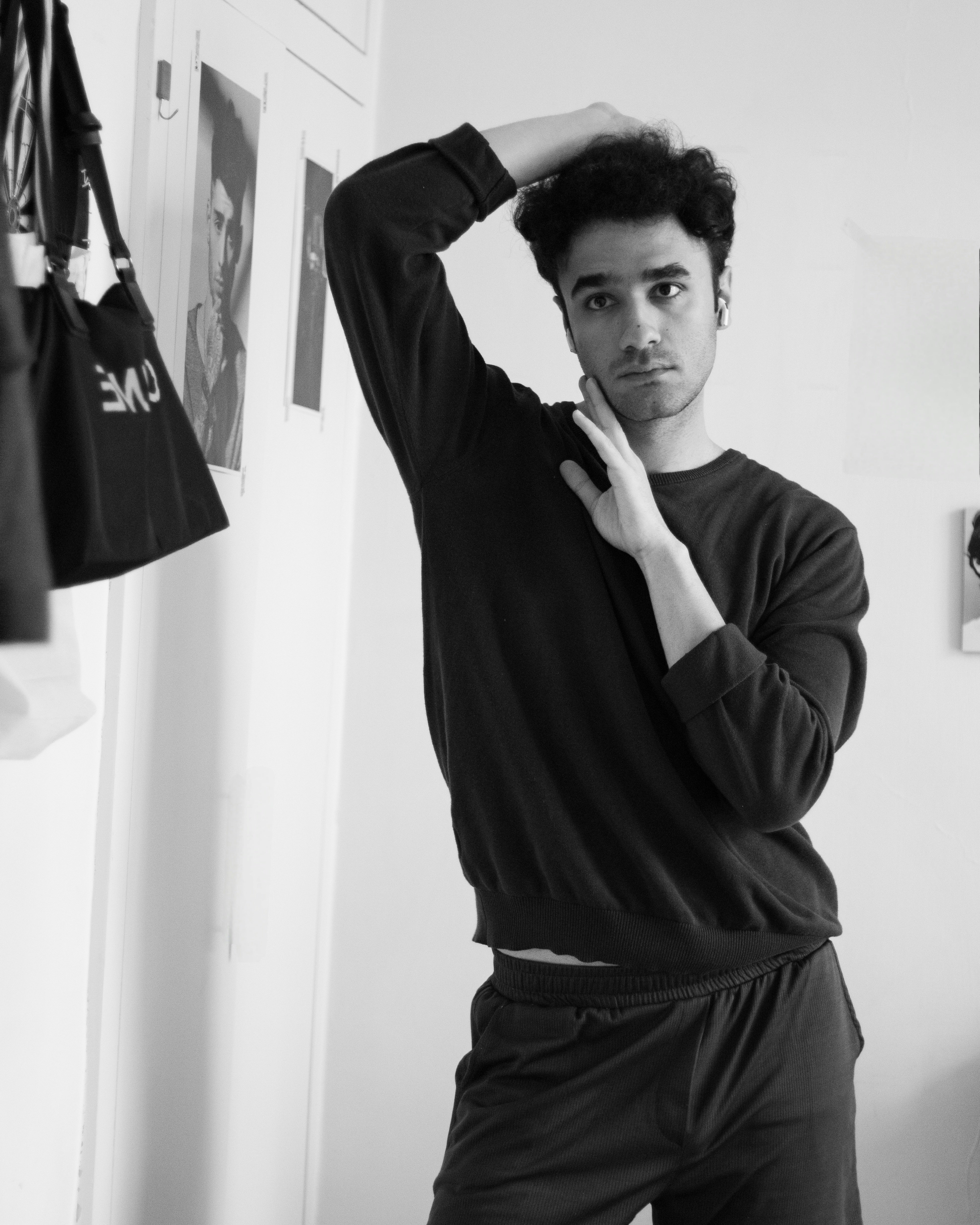 A man standing in front of a mirror with his hand on his head