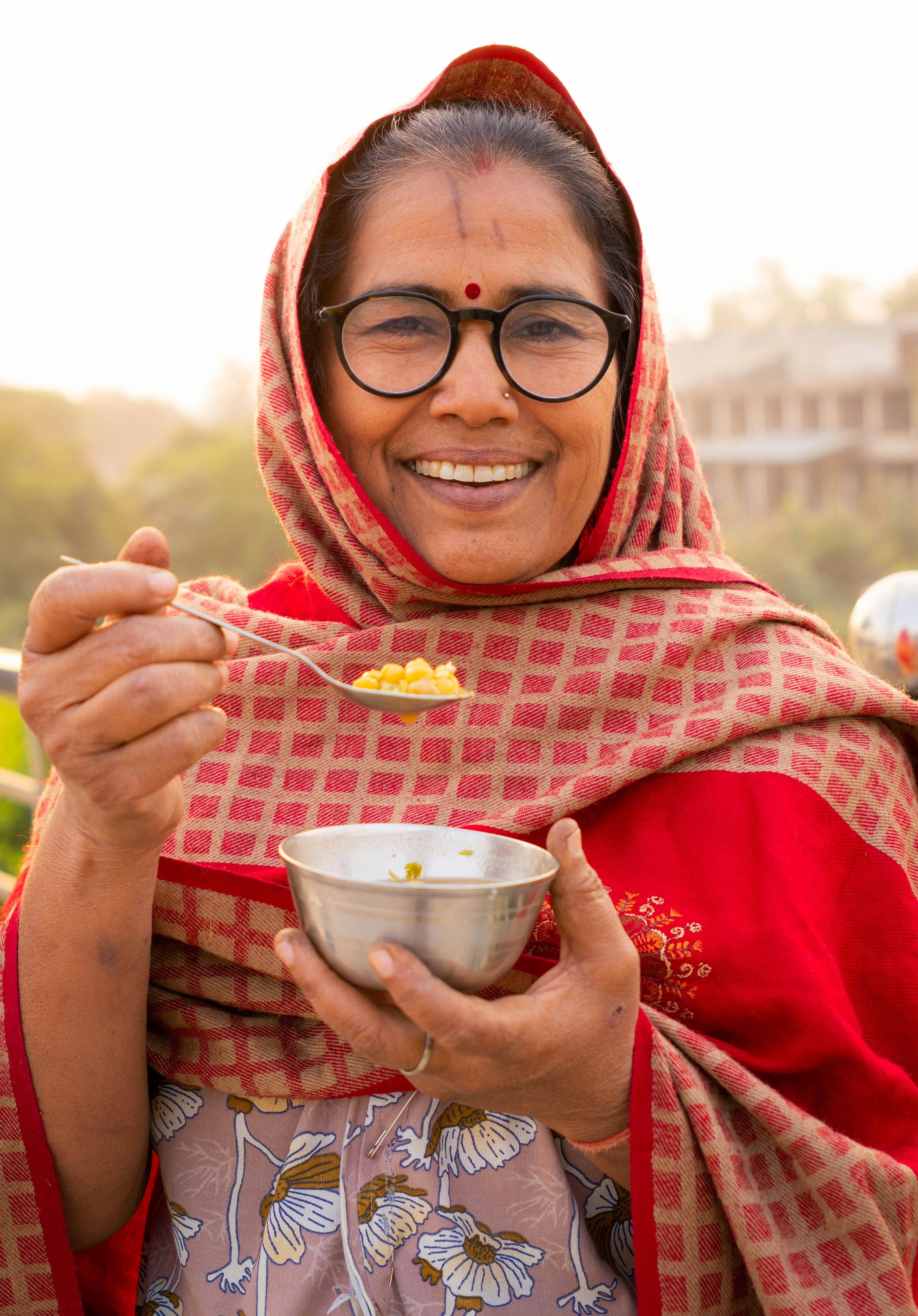 A woman in a red scarf holding a bowl of food