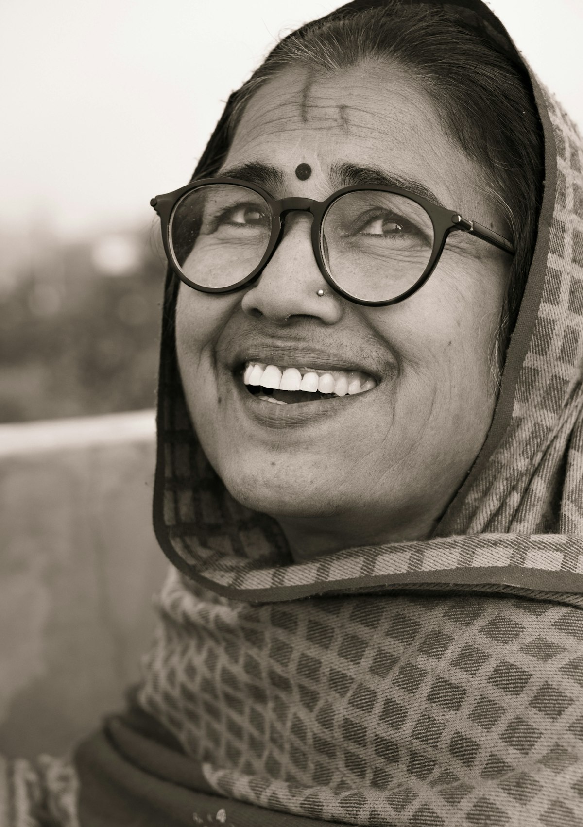 Woman wearing glasses smiling after a full smile makeover
