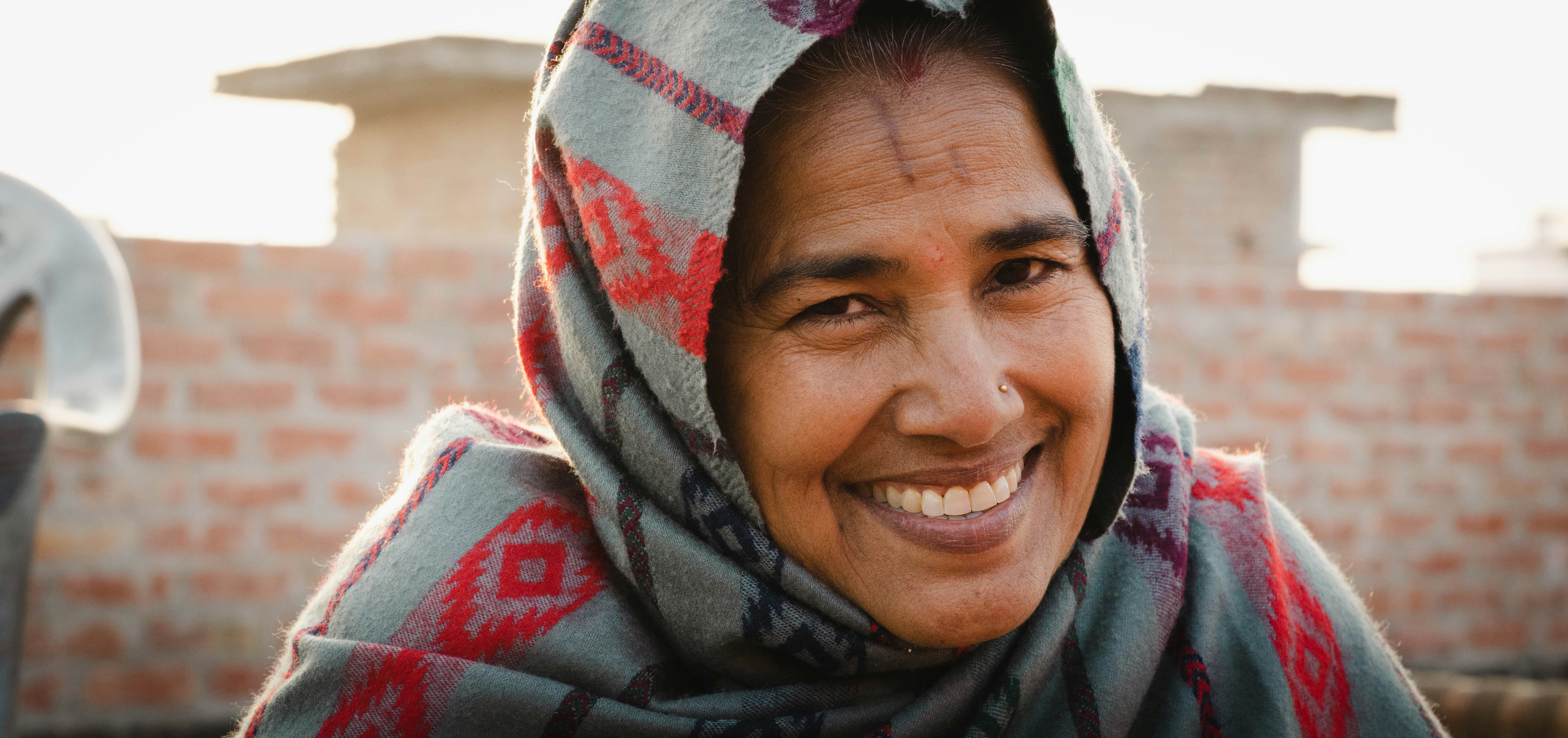 A man wearing a scarf and smiling at the camera