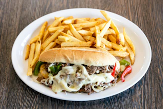 A white plate topped with a sandwich and fries
