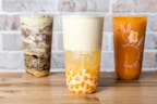 Three different colored cups sitting on top of a wooden table
