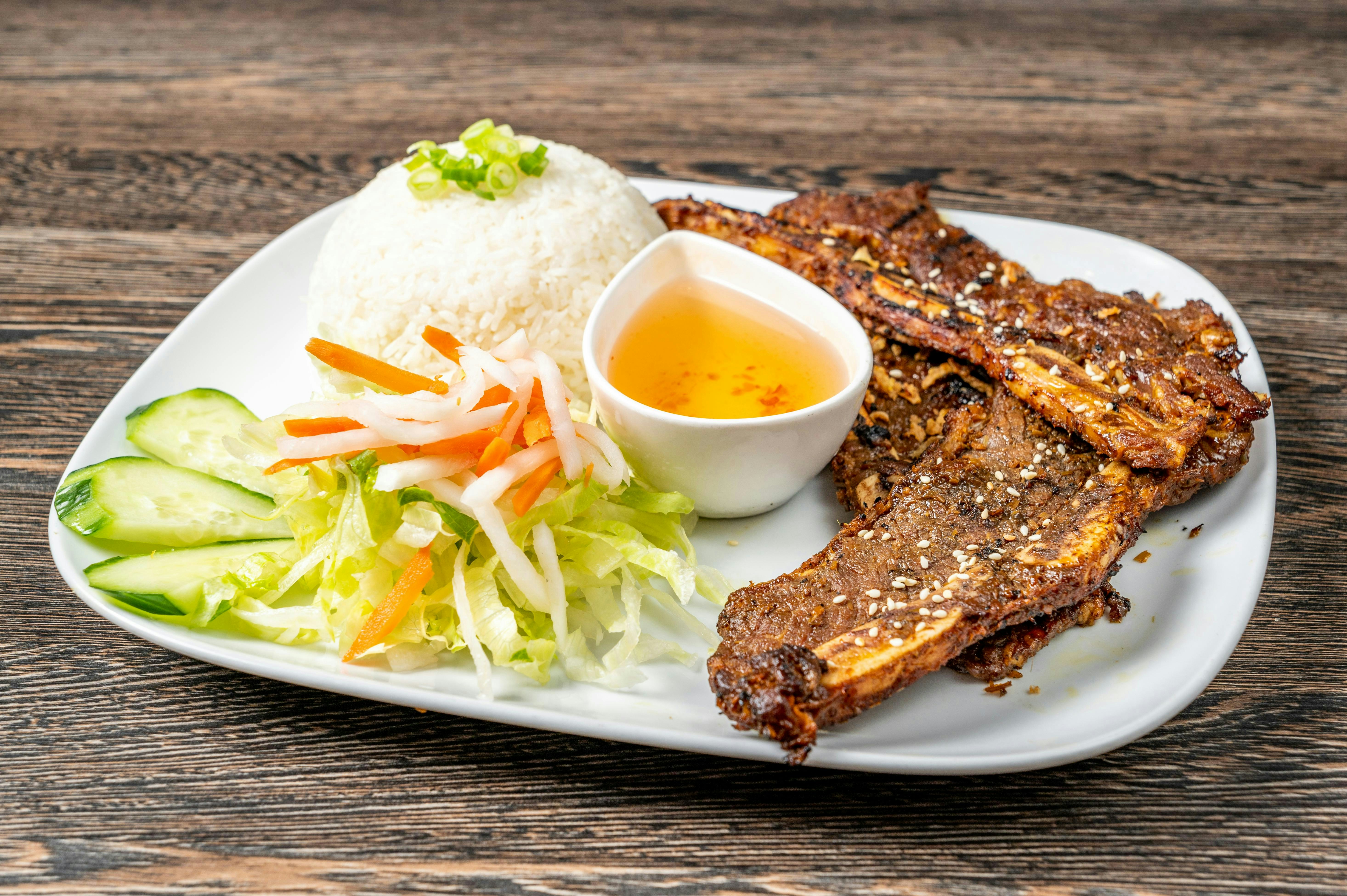 A white plate topped with meat and vegetables