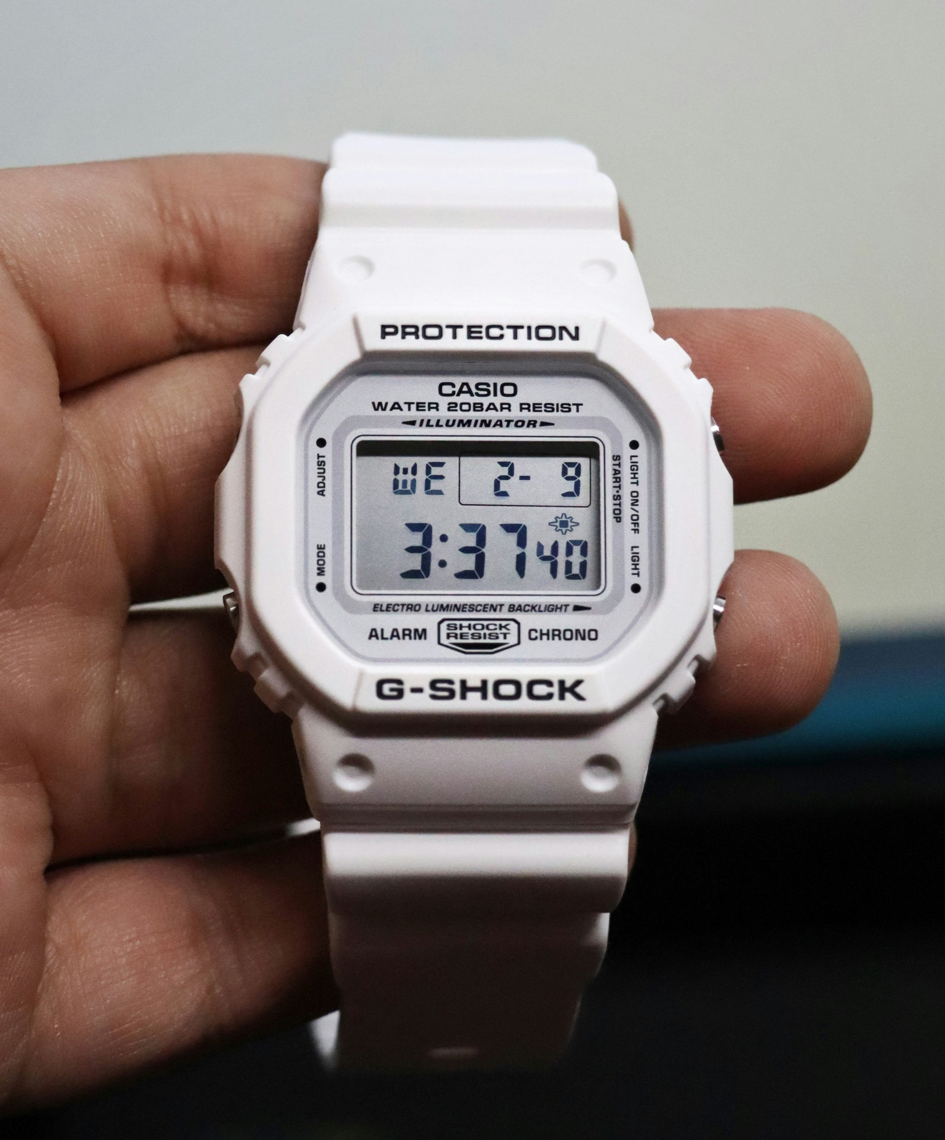 A person holding a white watch in their hand