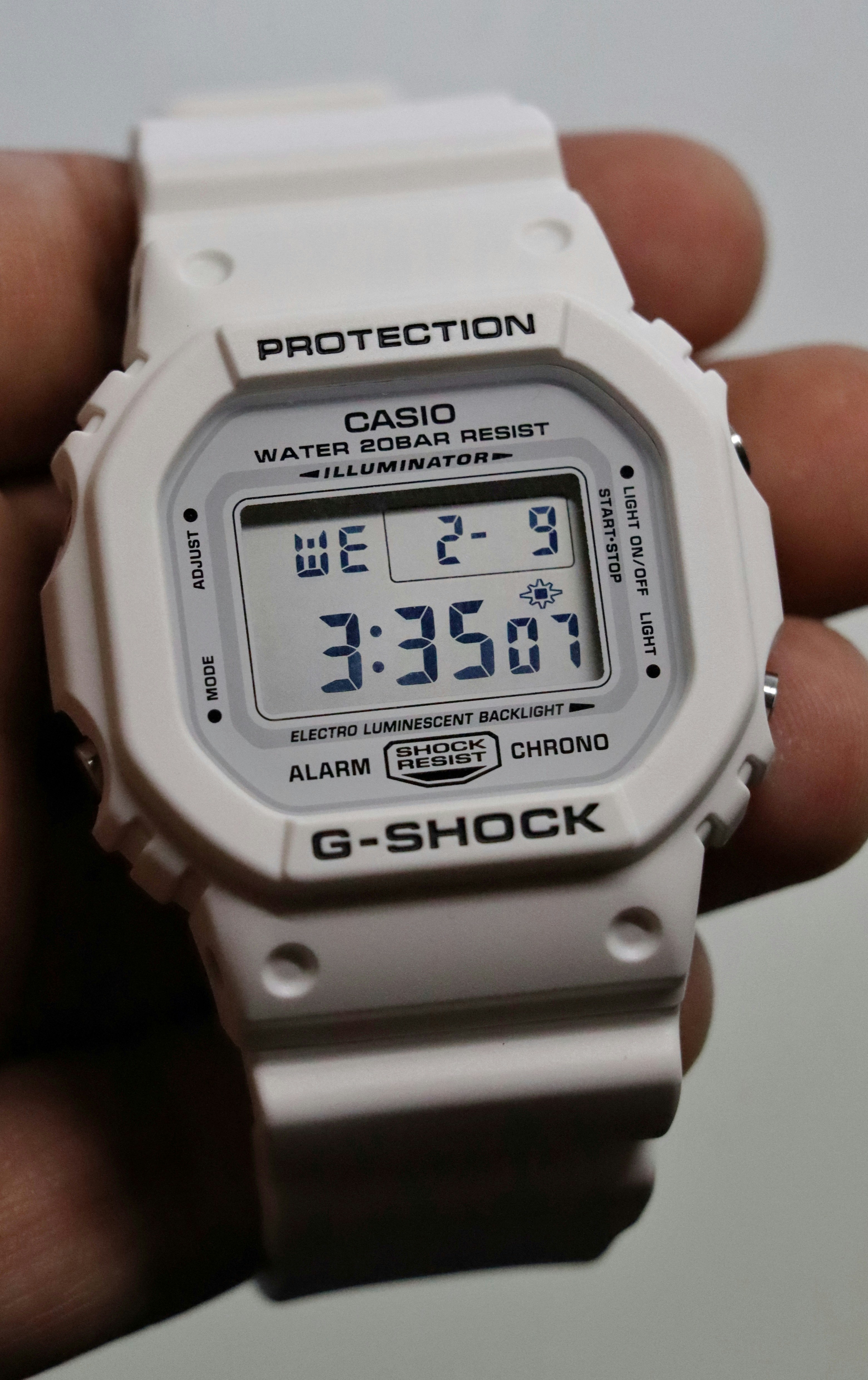 A person holding a white watch in their hand