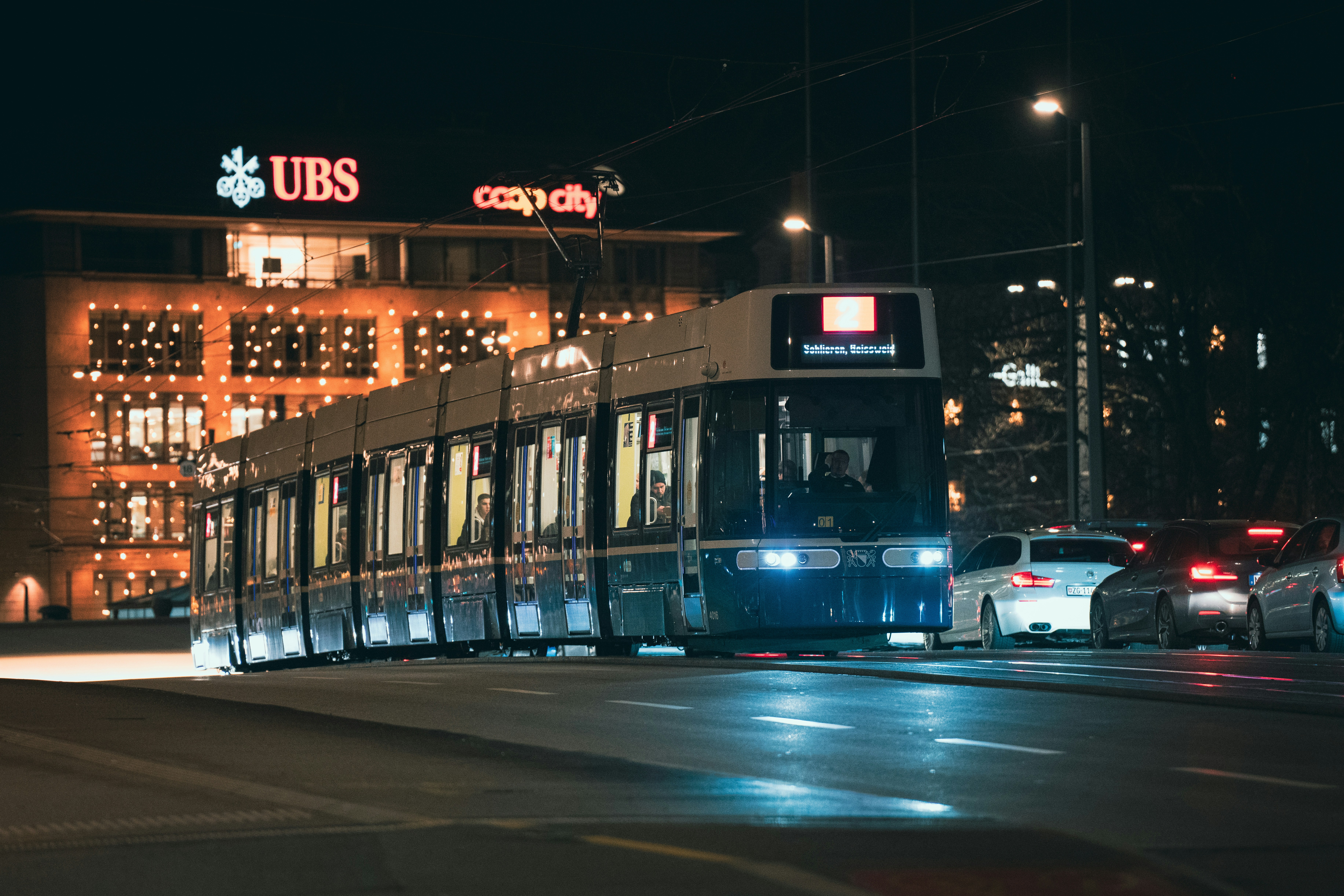 A double decker bus driving down a street at night