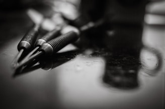 A black and white photo of pens and a cell phone