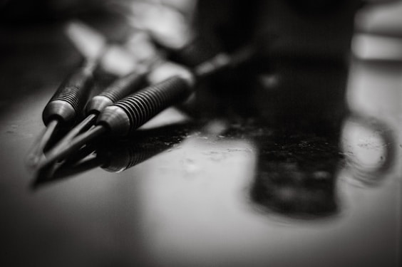 A black and white photo of pens and a cell phone