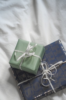 Two wrapped presents sitting on top of a bed