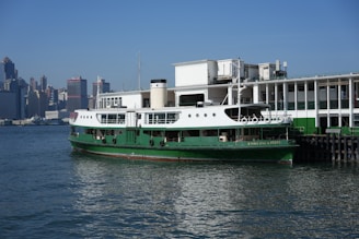 A large green and white boat in a body of water