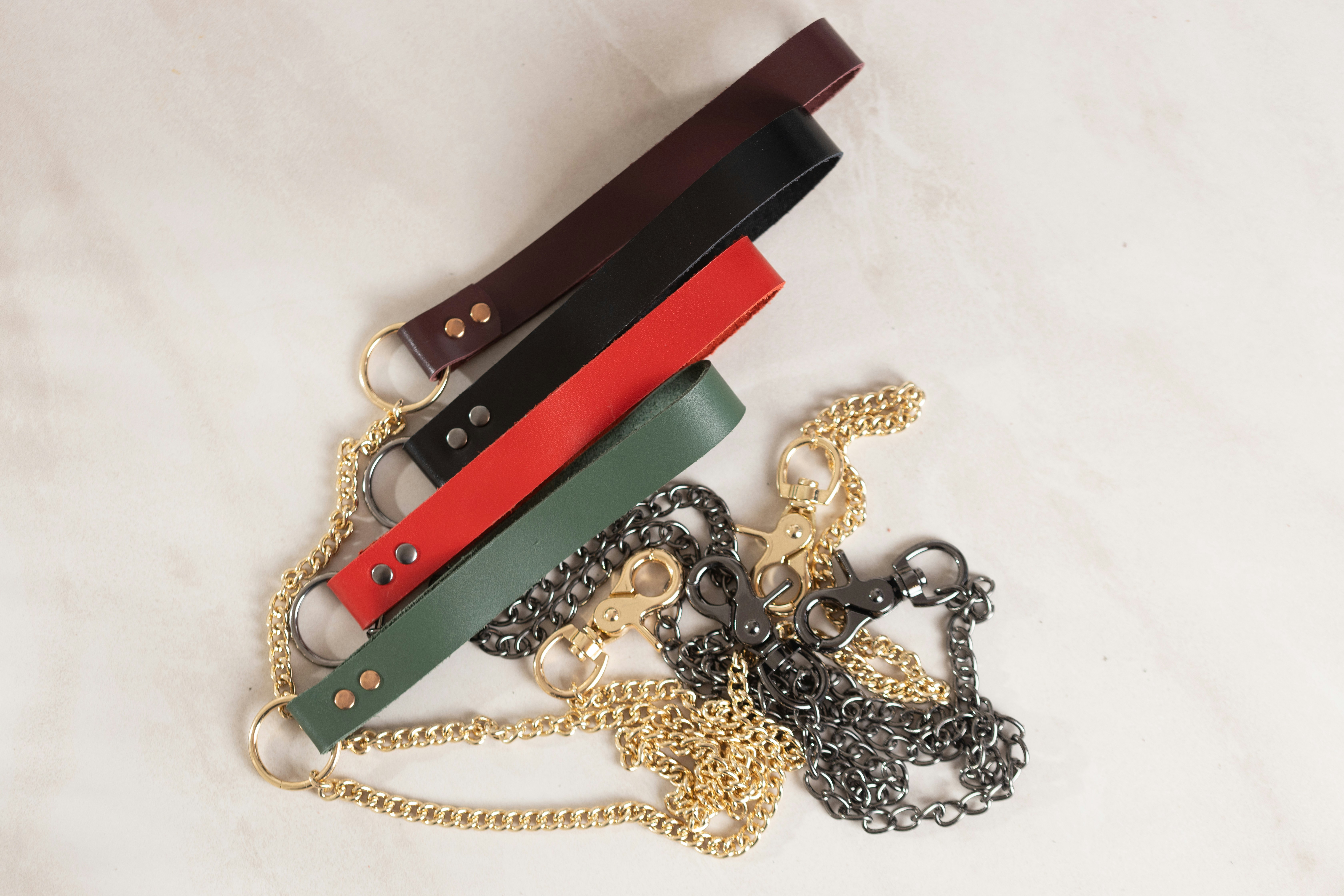 Various types of handcuffs sex toys laid out flat on a neutral background