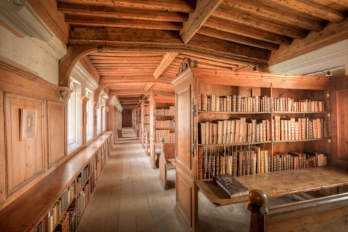 A long room with a lot of books on the shelves
