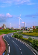 A highway with wind turbines in the background