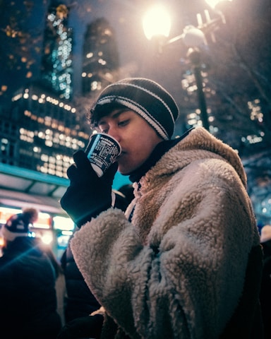 A person standing on a street talking on a cell phone