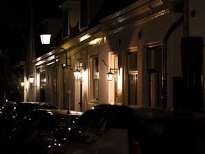 A row of parked cars sitting on the side of a street