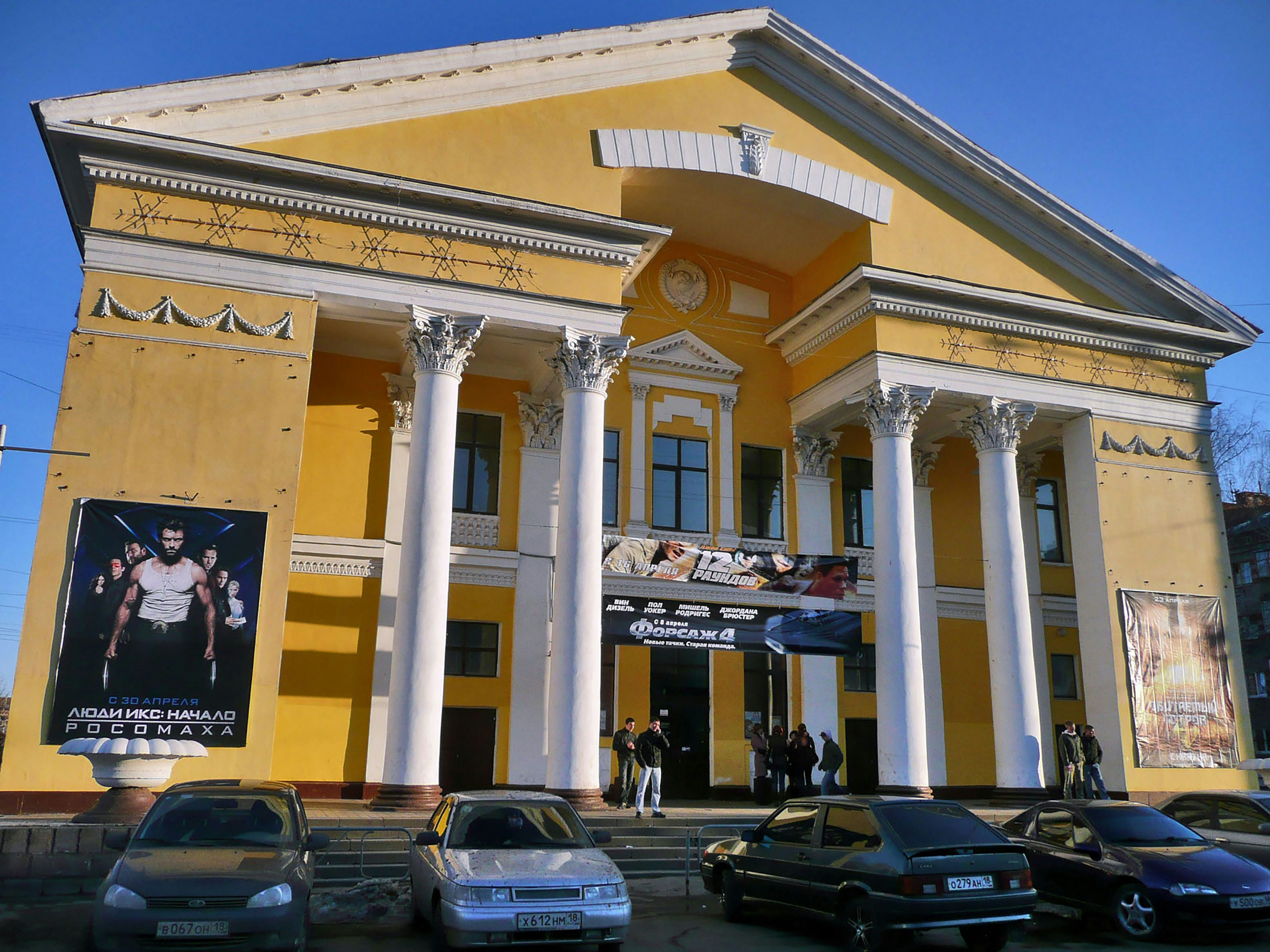 A large yellow building with columns and pillars