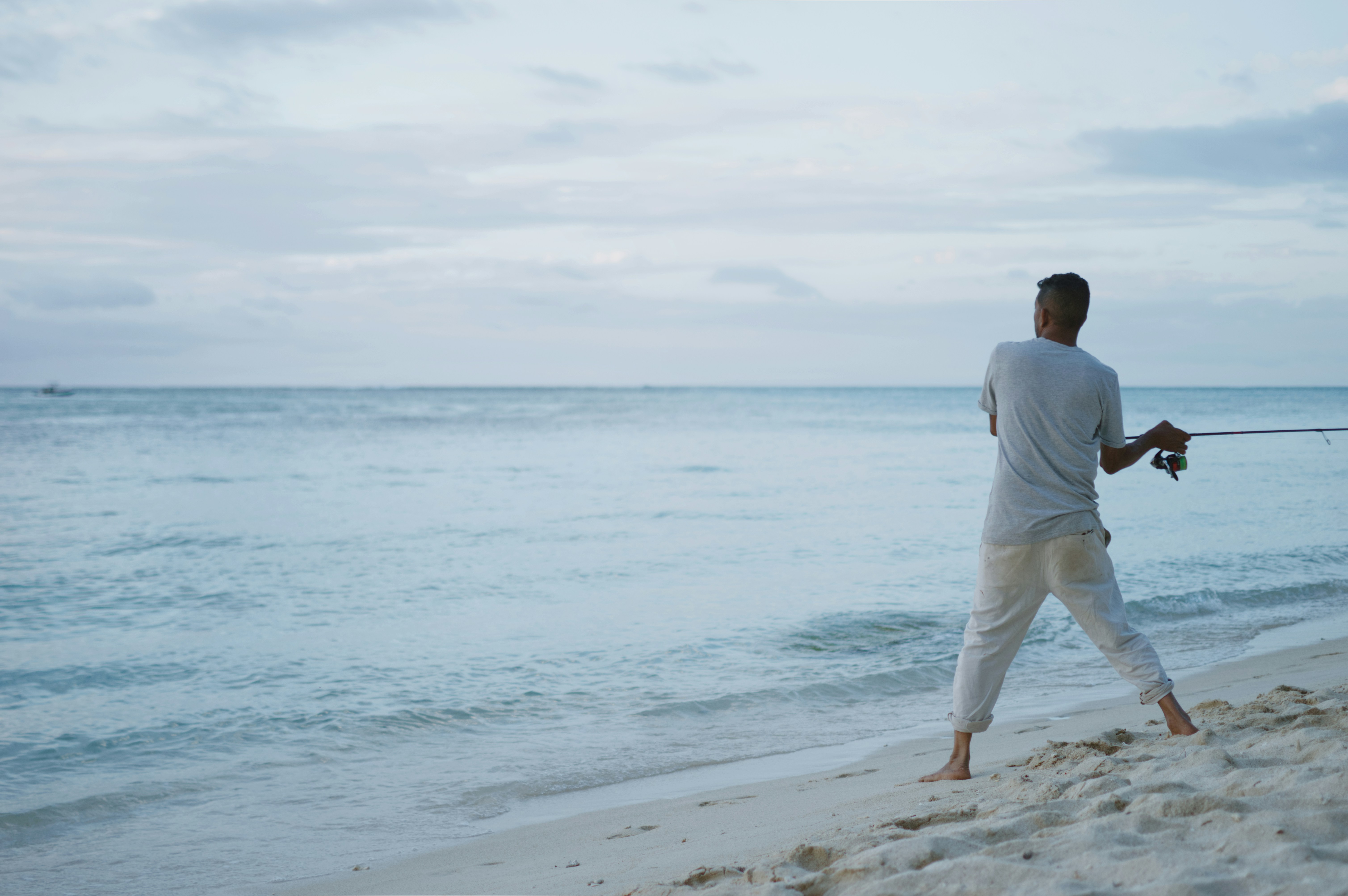 A man walking along the beach with a kite