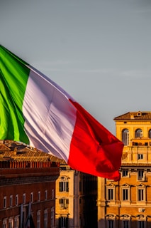 A large italian flag flying in front of a building