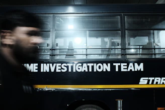 A blurry photo of a man walking in front of a bus