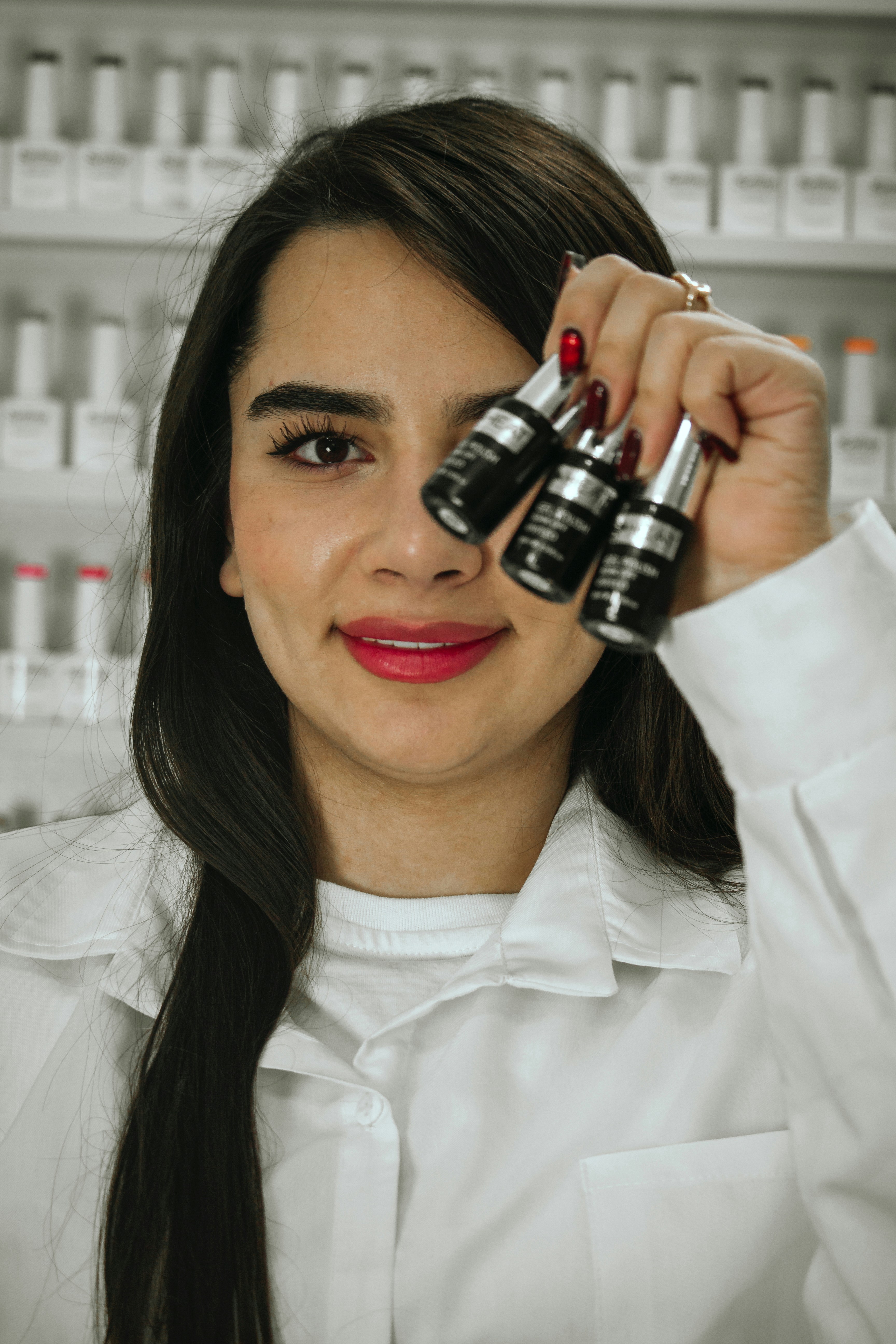 A woman in a white lab coat holding a pair of microscopes