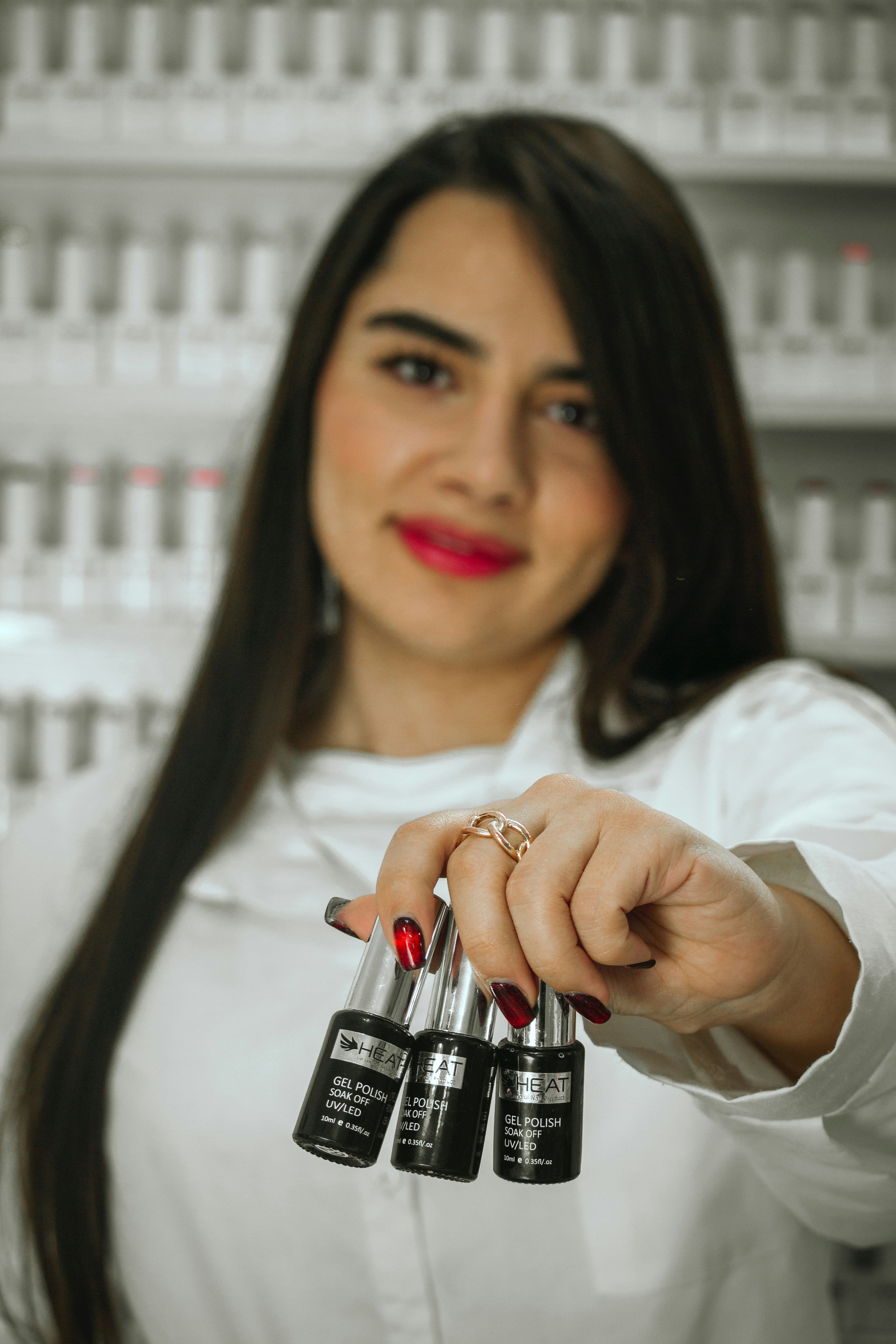 A woman holding three bottles of nail polish