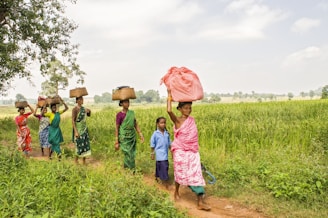 A group of people walking down a dirt road