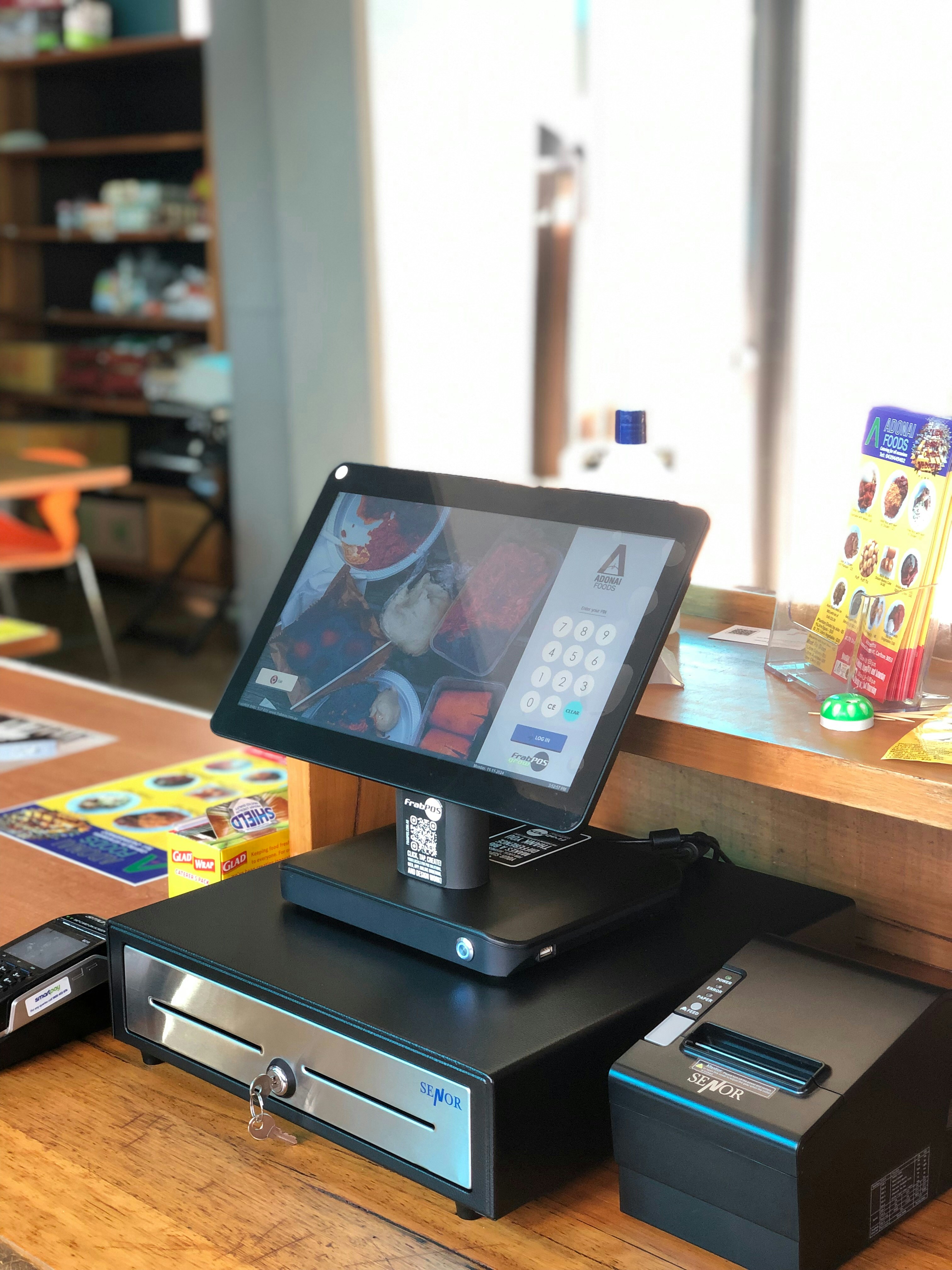 Modern POS terminal on restaurant counter with digital order management screen active