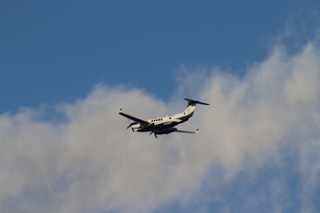 An airplane flying in the sky with a cloud in the background, Twin turboprop aircraft takes flight