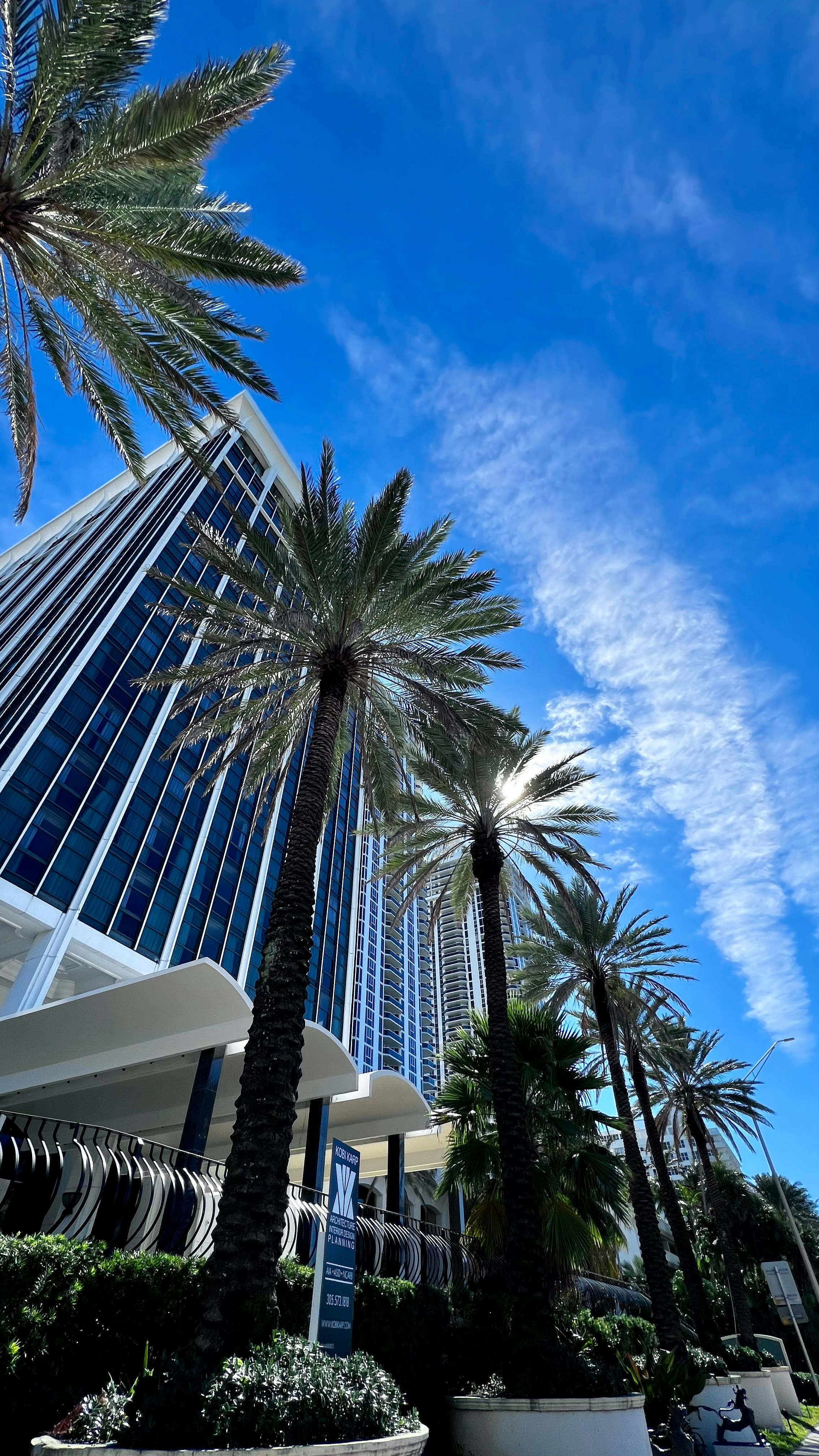 Un edificio alto con palme di fronte