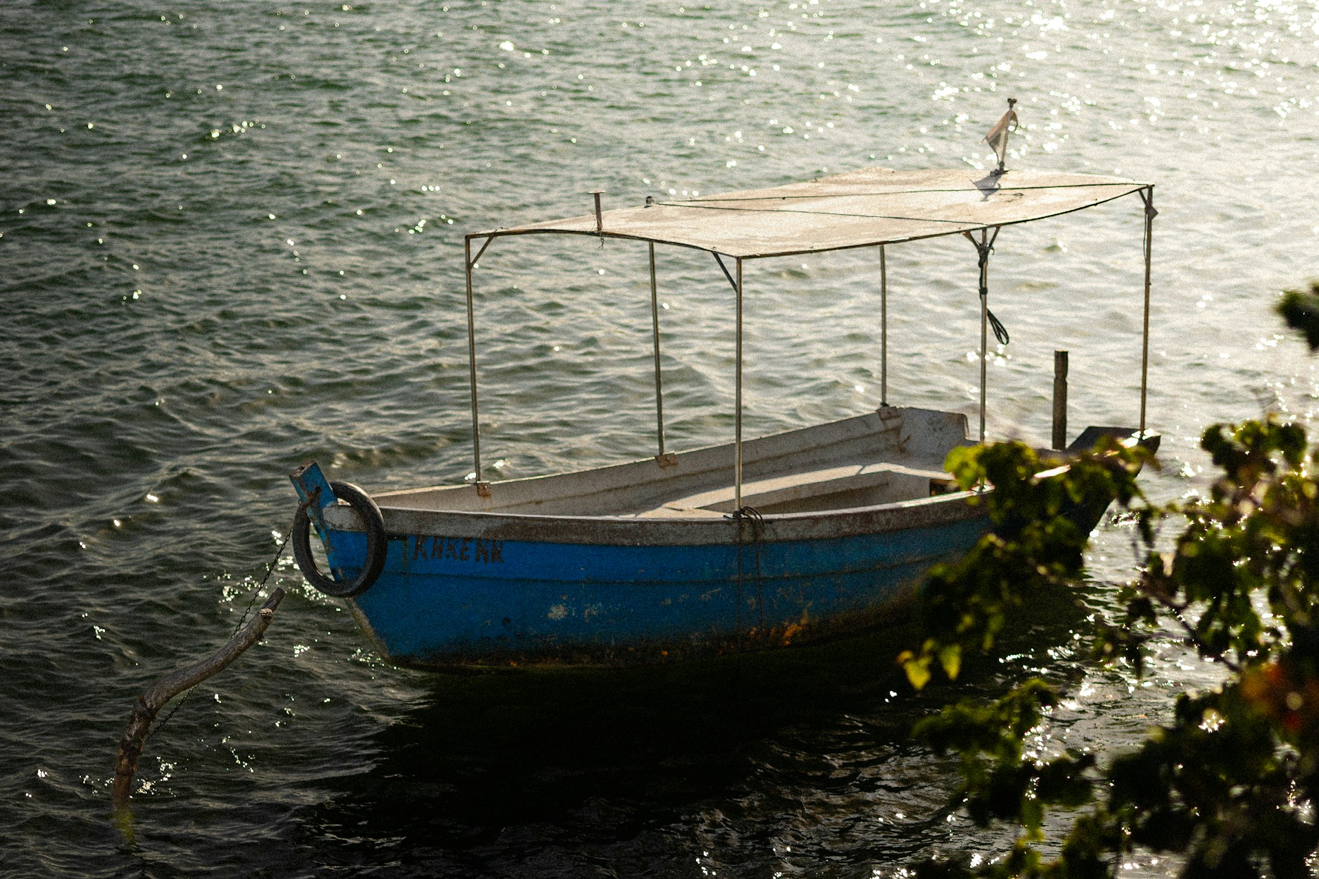 A small blue boat floating on top of a body of water