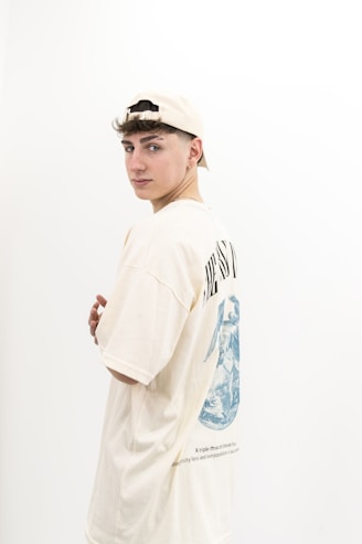 A young man standing in front of a white wall