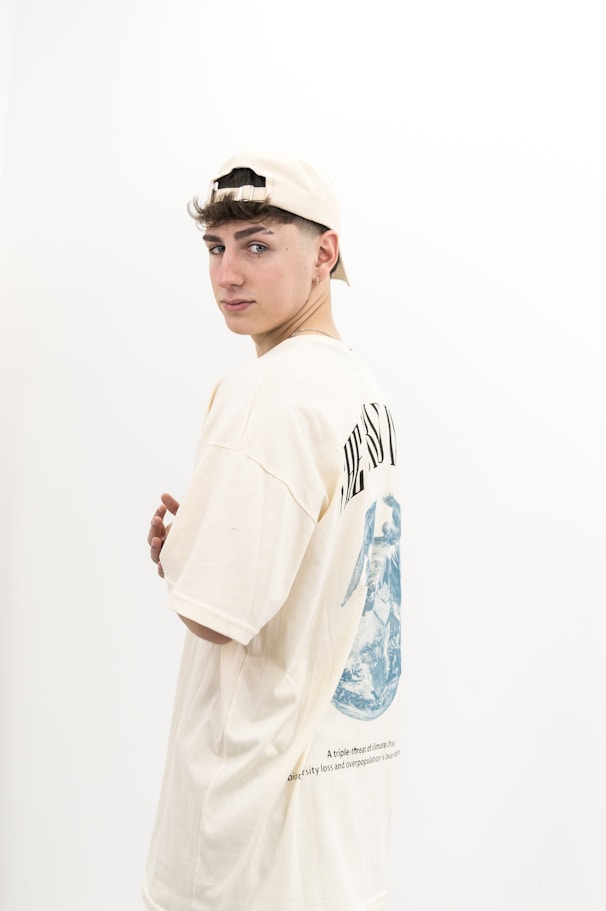 A young man standing in front of a white wall