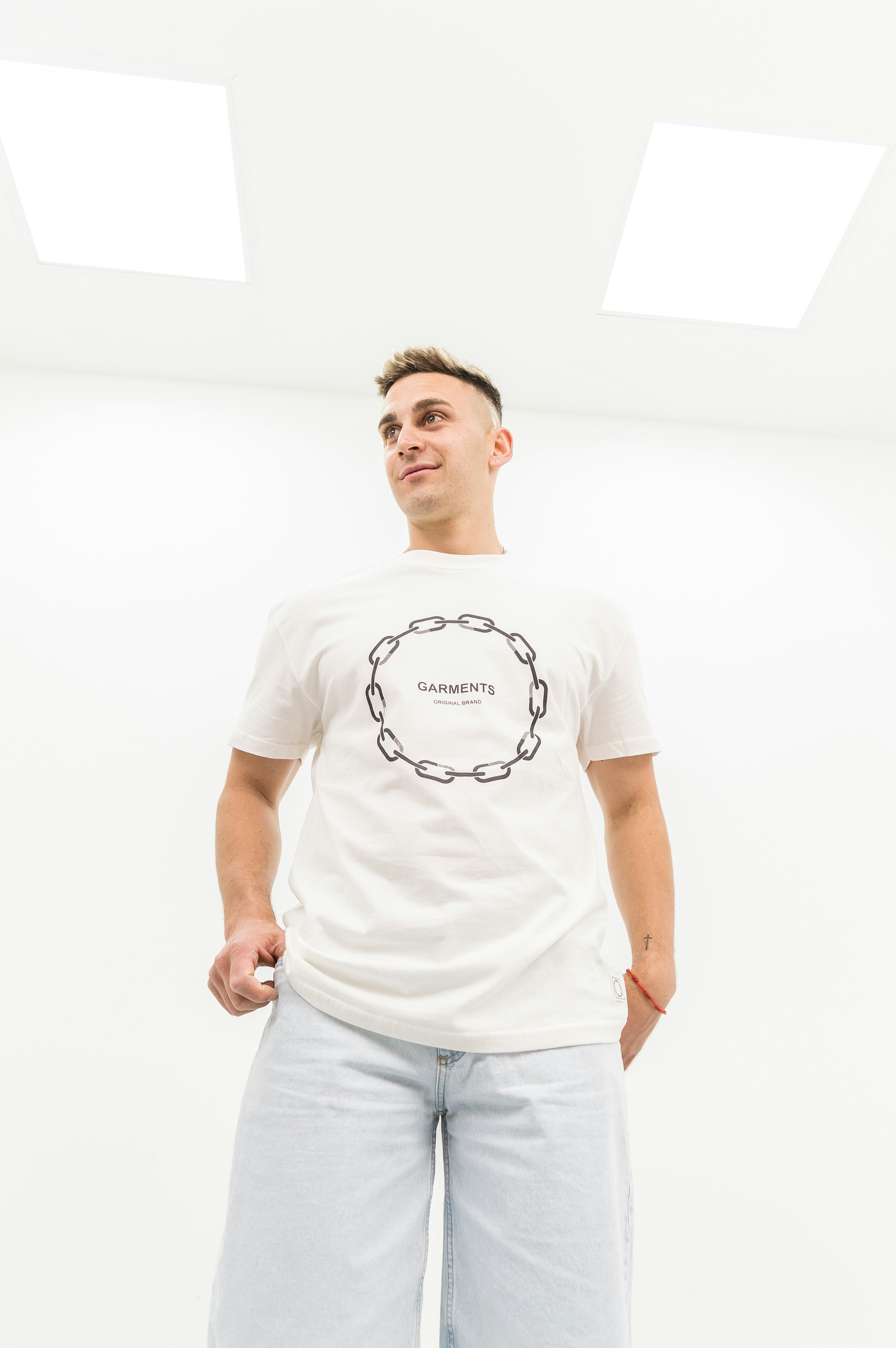 A man standing in a room with his hands in his pockets
